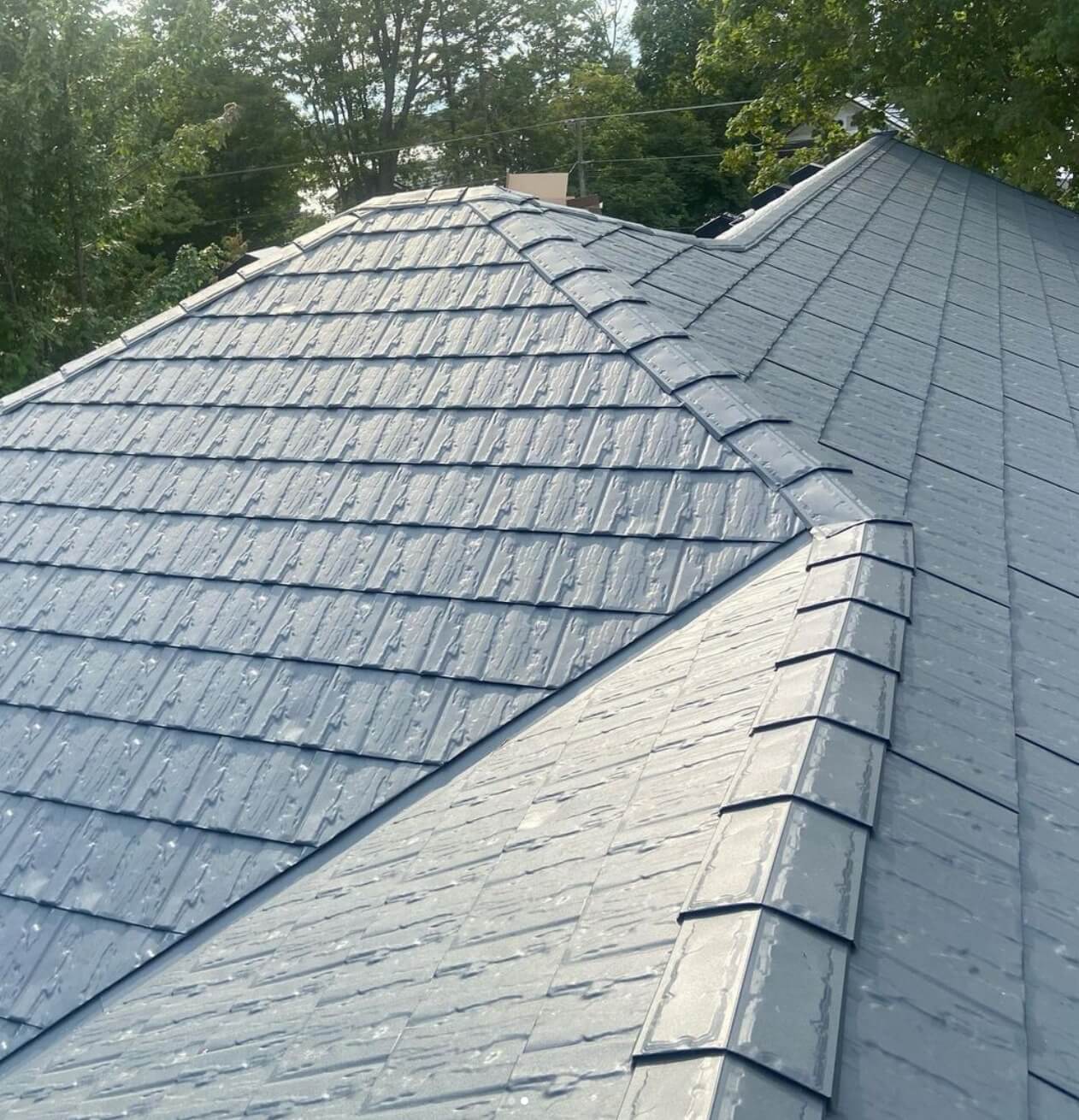 Metal Slate Roof Installation – Westpeak Roofing Process in Action Westpeak Metal Roofing crew member aligning and fastening metal slate panels during installation with precision and care.