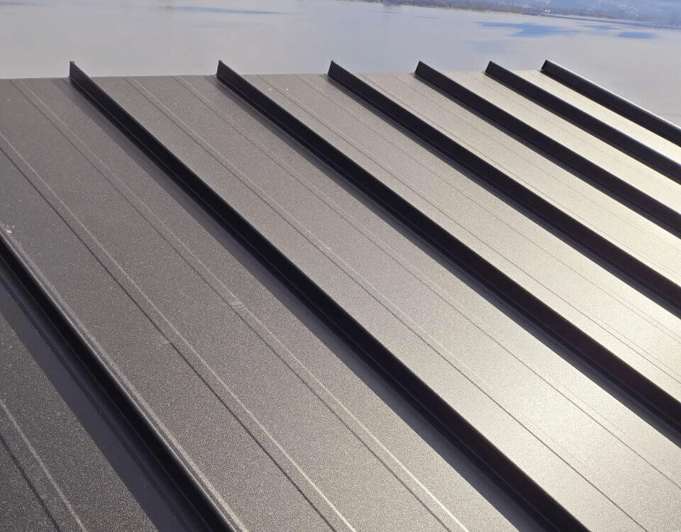 On-Site Panel Fabrication – Standing Seam Roofing in Kamloops Westpeak Metal Roofing crew member working on-site using standing seam panel equipment in Kamloops.