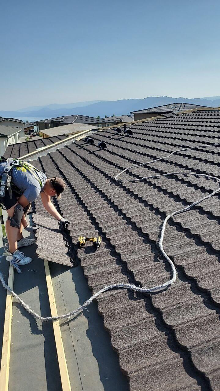 Finished Metal Roof with Gutter System – Okanagan Project Finished metal roof and gutter layout with surrounding foliage and nearby structures in Okanagan region.