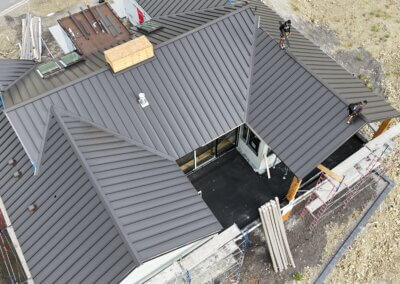 Large standing seam metal roof spanning a residential structure with modern architectural lines.